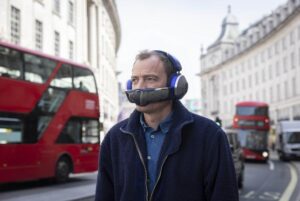 Man wearing Dyson Zone headphones with city background